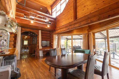 a dining room with a table and some windows at Secret Heaven in Yamanakako