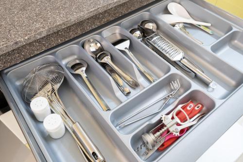 a tray with utensils in a kitchen sink at Luxe 2BHK 10min from GOI airport with Pool access in Dabolim