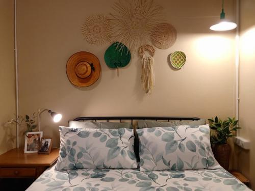 a bedroom with a bed with two pillows and clocks on the wall at Be Local BNB in Bangkok