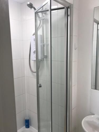 a shower with a glass door in a bathroom at Fantastic large 1 bed Loft Flat close to Heathrow - 77VFR5 in Cranford