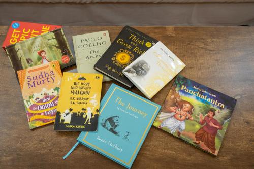 a group of books sitting on a table at Luxe 2BHK 10min from GOI airport with Pool access in Dabolim