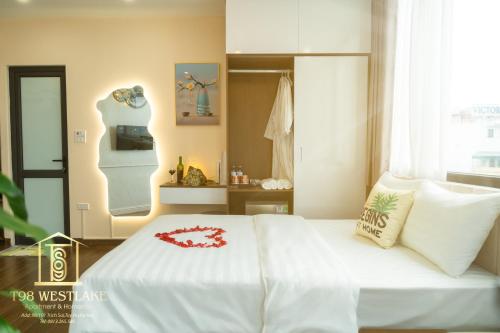 a bedroom with a white bed with a red flower on it at T98 Westlake Apartment in Hanoi