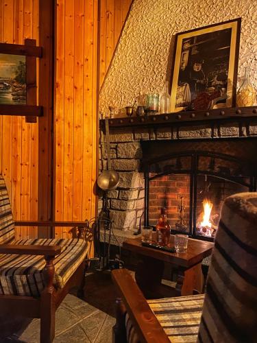 a living room with a fireplace with a bench and a table at Sunrise Inn & Spa in Pessinetto