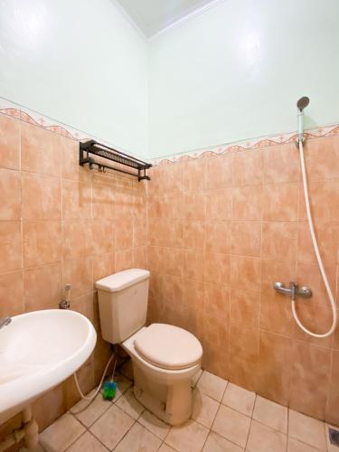y baño con aseo, lavabo y ducha. en Homestay Kamar Tamu Gedongkiwo, en Yogyakarta