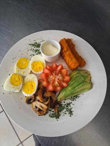 PostmasburgにあるStayの卵と野菜とソースが添えられた料理