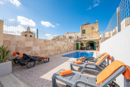 a pool with chaise lounge chairs and a swimming pool at Ta Kalang Holiday Home in Kerċem