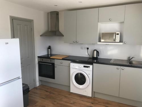 a kitchen with a washing machine and a washer at Fantastic large 1 bed Loft Flat close to Heathrow - 77VFR5 in Cranford