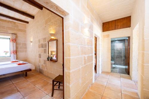 a room with a bed and a mirror at Ta Kalang Holiday Home in Kerċem