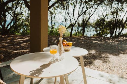 - une table avec un verre de jus d'orange et un bol de fruits dans l'établissement BAGHEERA Village Naturiste, à Linguizzetta