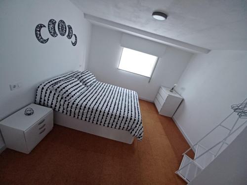 ein kleines Schlafzimmer mit einem Bett und einem Fenster in der Unterkunft Casa Montecelo in Paderne