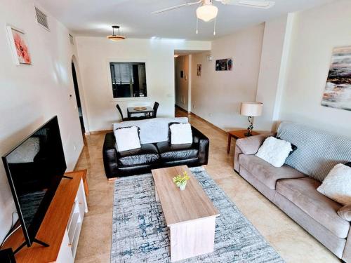 ein Wohnzimmer mit Sofa und Tisch in der Unterkunft Duquesa Suites Gardens ground floor close to Port, beach in Manilva