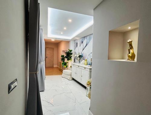 - un couloir avec une salle de bains pourvue d'un lavabo et d'un miroir dans l'établissement ART HOUSE, à Nuoro