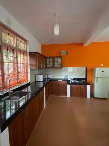 a large kitchen with wooden cabinets and a white refrigerator at Virangani in Kandy