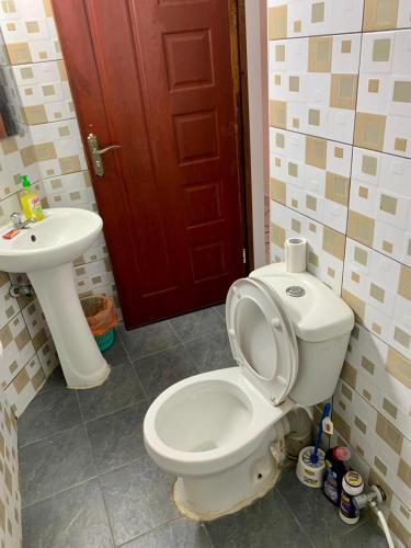 Łazienka z białą toaletą i umywalką w obiekcie Cozy 2 bedroom, master en-suite Apartment in Bamburi with secure environment WIFI Netflix and 10min drive to the beach w mieście Mombasa