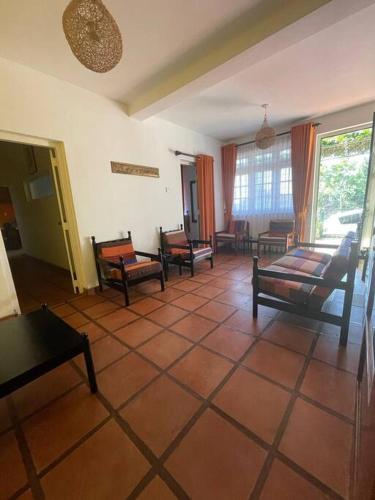 a living room with chairs and a tiled floor at Virangani in Kandy