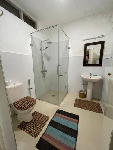 a bathroom with a shower and a toilet and a sink at Virangani in Kandy