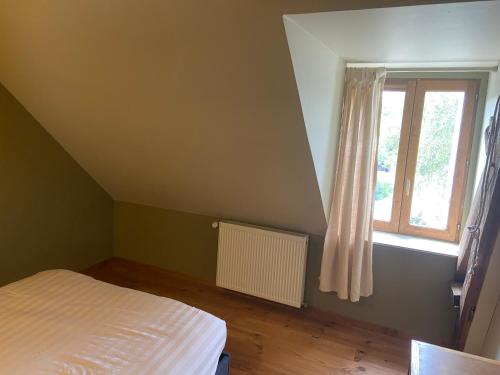 a bedroom with a bed and a window at Maison de campagne authentique et chaleureuse in Fougerolles