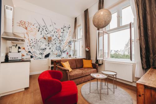 a living room with a couch and a red chair at KH Apartments Universitaet in Vienna