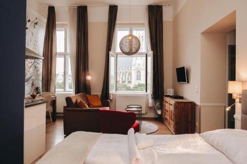 ウィーンにあるKH Apartments Universitaetのベッドとリビングルームが備わるホテルルームです。