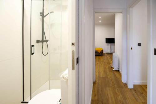 een badkamer met een douche en een glazen deur bij La casa del patio in La Arboleda