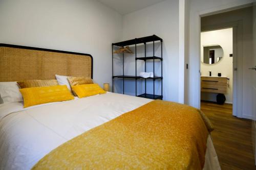a bedroom with a large bed with yellow pillows at La casa del patio in La Arboleda