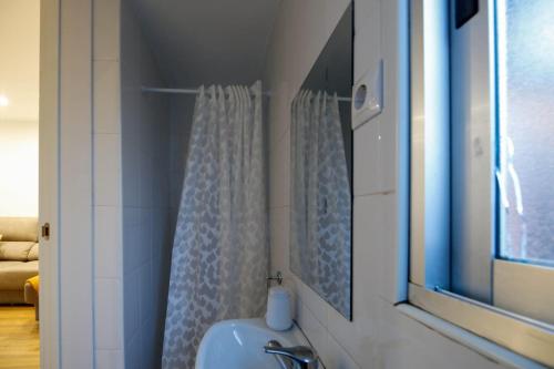a bathroom with a sink and a shower curtain at La casa del patio in La Arboleda