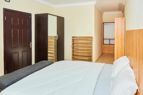a bedroom with a large bed and a closet at Mainstream Shortlet Apartments in Gbogije