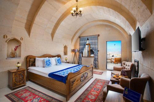 烏奇薩爾的住宿－Simera in Cappadocia - Special Class，一间带一张床铺的卧室,位于带拱门的房间