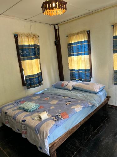 a large bed in a room with windows at Blue stone in Pai