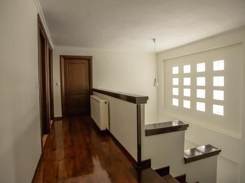 an empty hallway with a staircase and a window at Villa Portitsa in Kardítsa