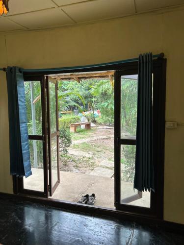 an open window with a view of a yard at Blue stone in Pai