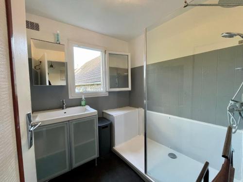 a bathroom with a sink and a tub and a shower at Chez Madame Titus in Ormoy-Villers