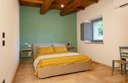 ein Schlafzimmer mit einem Bett mit gelber Bettwäsche und einem Fenster in der Unterkunft Casa Vespina Agriturismo Biologico in Orvieto