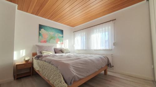 Schlafzimmer mit einem Bett mit Holzdecke in der Unterkunft Privatunterkunft in Celle in Celle