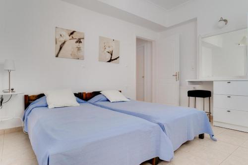 1 dormitorio blanco con 1 cama con sábanas azules en Villa Lilly, en Tragaki