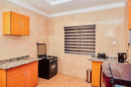 a kitchen with a black stove and a window at Mainstream Shortlet Apartments in Gbogije