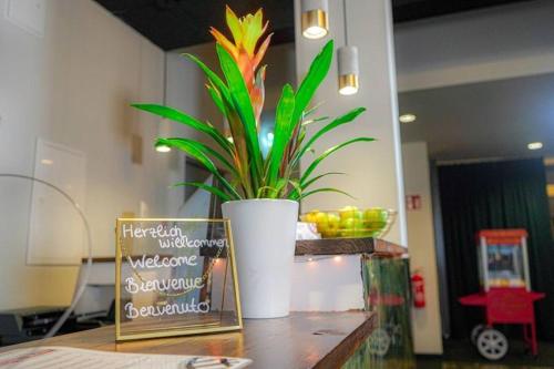 uma planta num vaso branco sentado numa mesa em Amical Hotel Hagen - Am Hauptbahnhof em Hagen