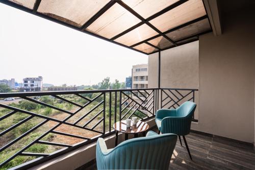 a room with two chairs and a table and a balcony at Regenta Place Igatpuri in Igatpuri