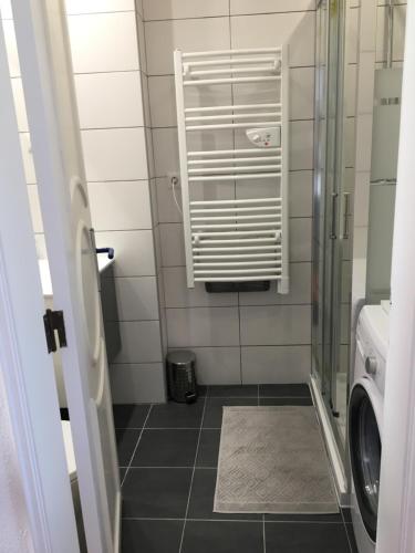 a bathroom with a washer and a glass shower door at Appartement, praia da rocha, PORTIMAO in Portimão