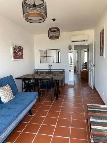 a living room with a blue couch and tables at Appartement, praia da rocha, PORTIMAO in Portimão