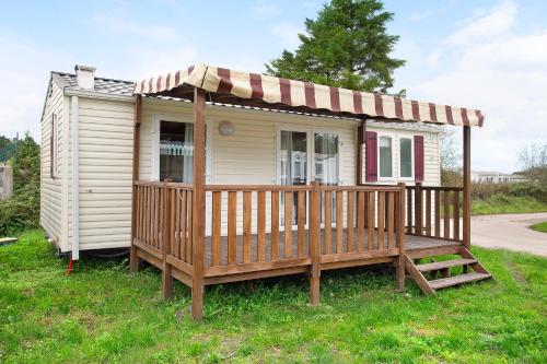 a small house with a porch and a deck at Bungalow T2 i i i - 15 Min Nazaré in Pataias