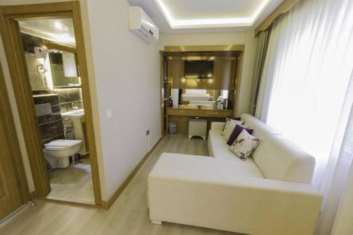 mars hotel في إسطنبول: غرفة معيشة مع أريكة بيضاء وحمام