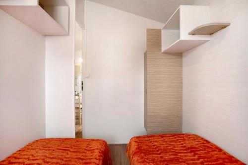 two beds in a room with white walls at Bungalow T2 i i i - 15 Min Nazaré in Pataias