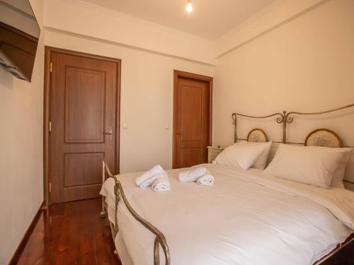 a bedroom with a large white bed with towels on it at Villa Portitsa in Kardítsa