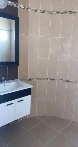 a bathroom with a white sink and a mirror at Dar el benet in Djerba