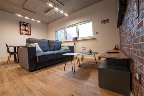 a living room with a couch and a brick wall at O'Kub du Ried in Rossfeld