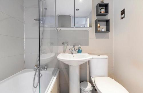 a bathroom with a sink and a toilet and a shower at Charming apartment, sleeps 4- 15 mins to Central in London