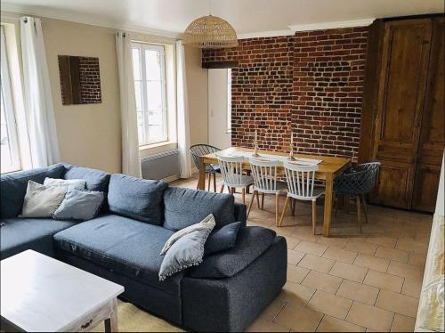 un salon avec un canapé bleu et une table dans l'établissement Duplex de charme 70m2 proche de Honfleur, à Fiquefleur-Équainville