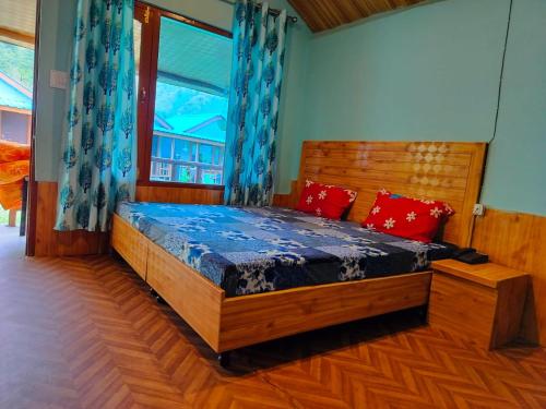 a bedroom with a large wooden bed with a window at Lee Garden Himalayan Wooden Cottages in Kasol