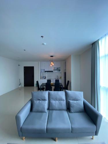 a blue couch in a living room with a table at Formosa Spacious Apartments with Netflix & Pick Up Service by MESA in Nagoya